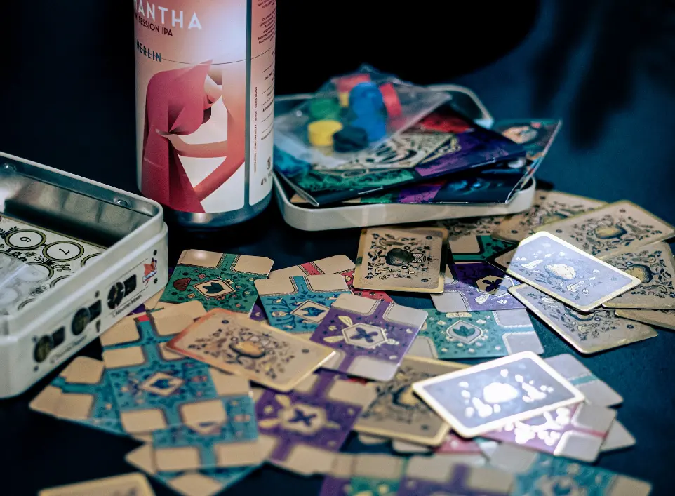 a can of beer sitting next to a pile of playing cards